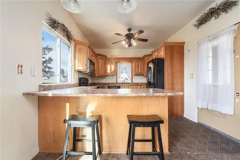 a large kitchen with kitchen island granite countertop wooden floor and stainless steel appliances