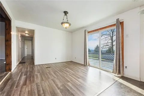a view of an empty room with glass door and windows