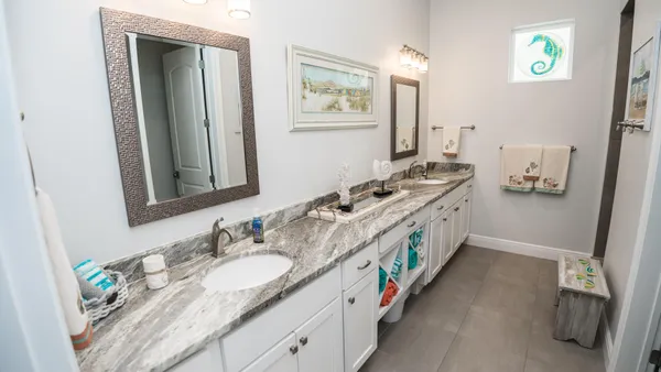 a bathroom with a granite countertop double vanity sink and a mirror