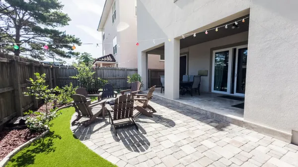 a view of a dinning tables and chairs in backyard of the house