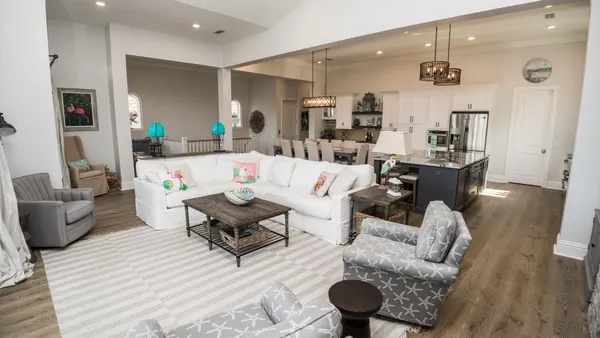 a kitchen with stainless steel appliances granite countertop a dining table chairs cabinets a refrigerator and a sink
