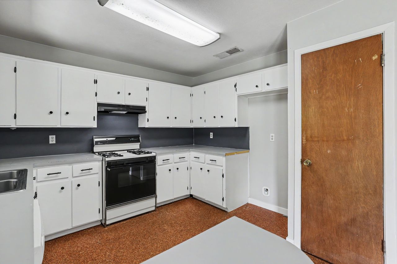 1811 Terry Lane Georgetown, TX 78628 - Photo 12 of 40 Functional kitchen offering ample white cabinetry and durable flooring for daily living.