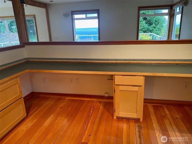 a view of a room with wooden floor and a window