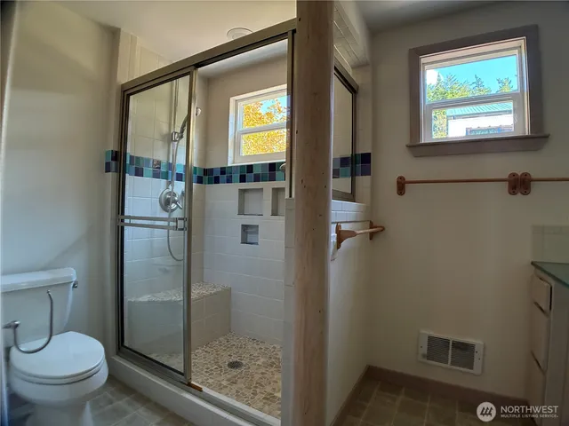 a bathroom with a toilet and a shower