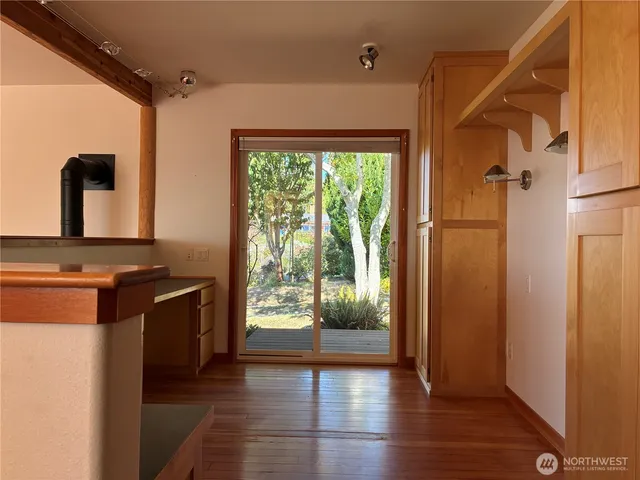 a view of a kitchen with a refrigerator and wooden floor