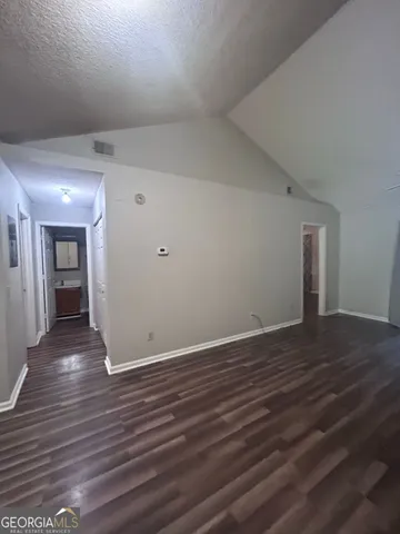 a view of an empty room with wooden floor