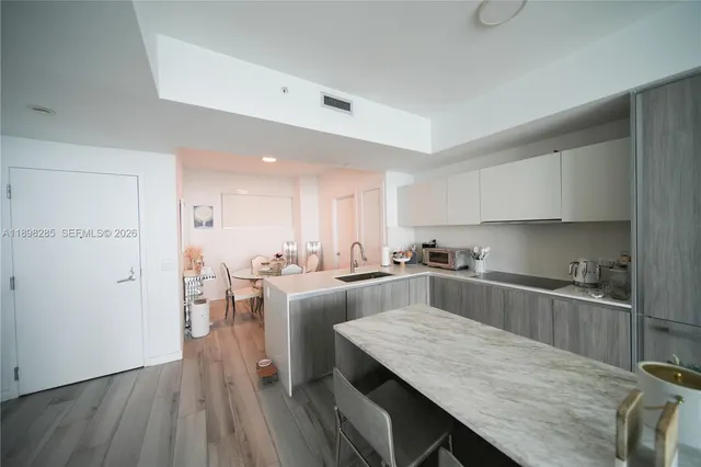a kitchen with cabinets wooden floor and stainless steel appliances