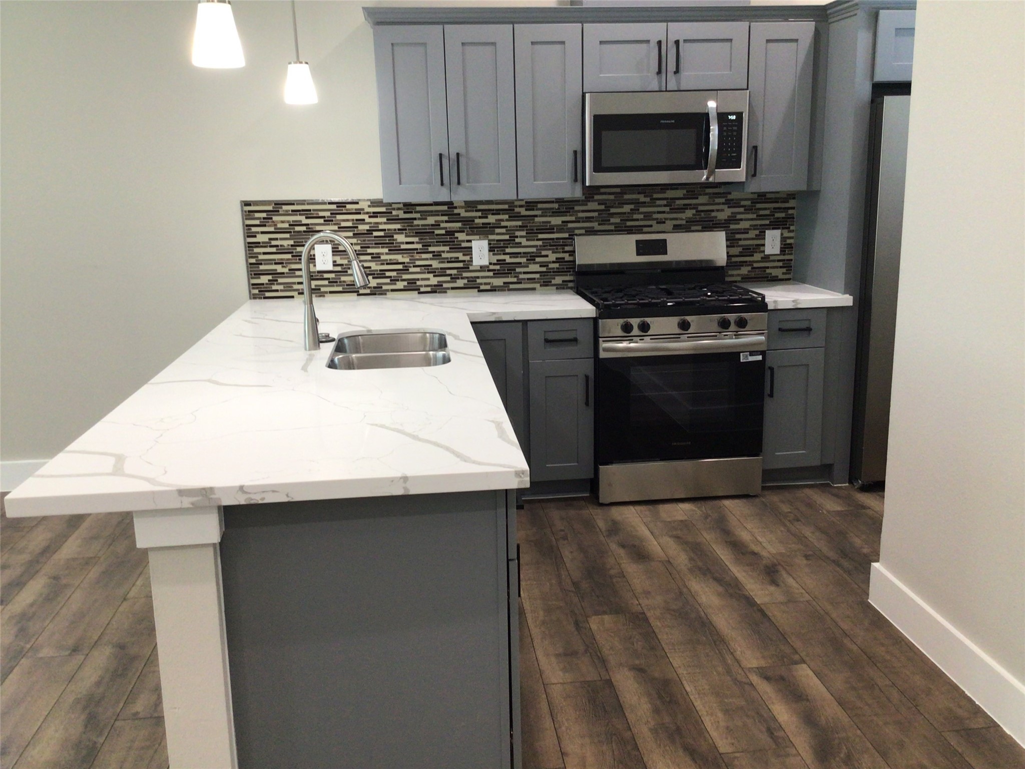 2109 Marnel Road, Unit E Houston, TX 77055 - Photo 8 of 29 a kitchen with a sink a stove and microwave