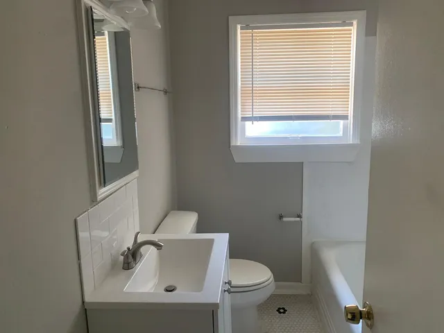 a bathroom with a sink a toilet and a mirror