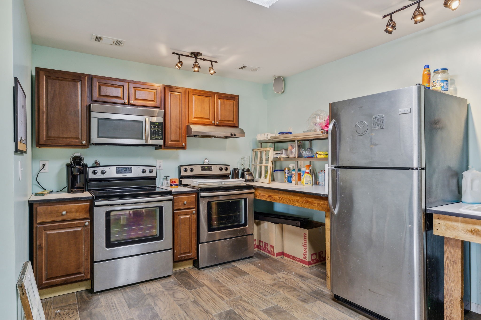 635 Cane Creek Road Hohenwald, TN 38462 - Photo 41 of 71 a kitchen with stainless steel appliances granite countertop a stove top oven a refrigerator and a microwave