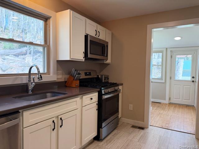 26 Woods Road Barryville, NY 12719 - Photo 5 of 34 a kitchen with stainless steel appliances granite countertop a sink a stove and a microwave oven