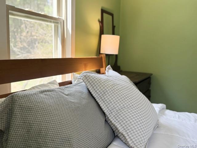 26 Woods Road Barryville, NY 12719 - Photo 10 of 34 a bedroom with a bed and a lamp next to a window
