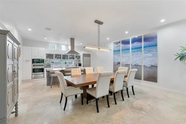 a dining area with a table chairs and a kitchen view