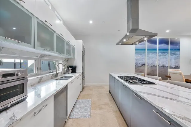 a large kitchen with stainless steel appliances granite countertop a stove and a sink