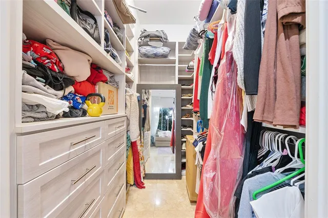 a view of walk in closet with clothes