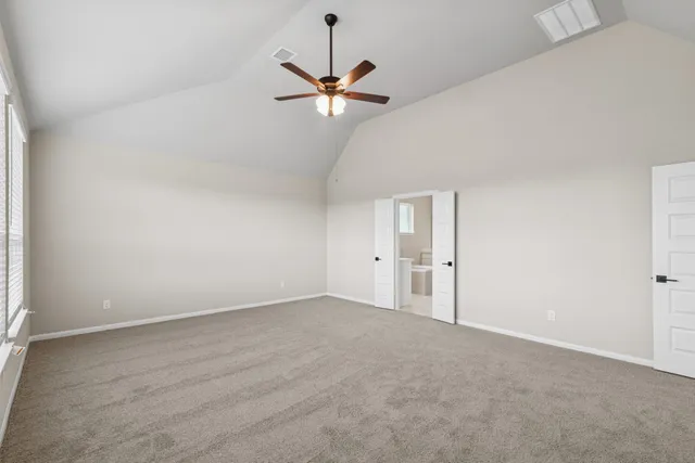 a view of a room with a ceiling fan and window