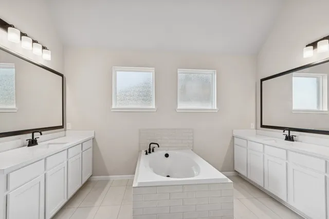 a bathroom with 2 sink tub and a mirror