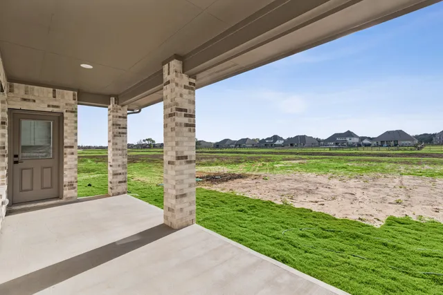 a front view of a house with a dirt yard and a garage