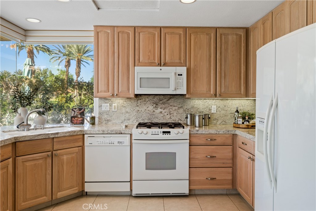 37 Oak Tree Drive Rancho Mirage, CA 92270 - Photo 11 of 54 a kitchen with white cabinets and white appliances
