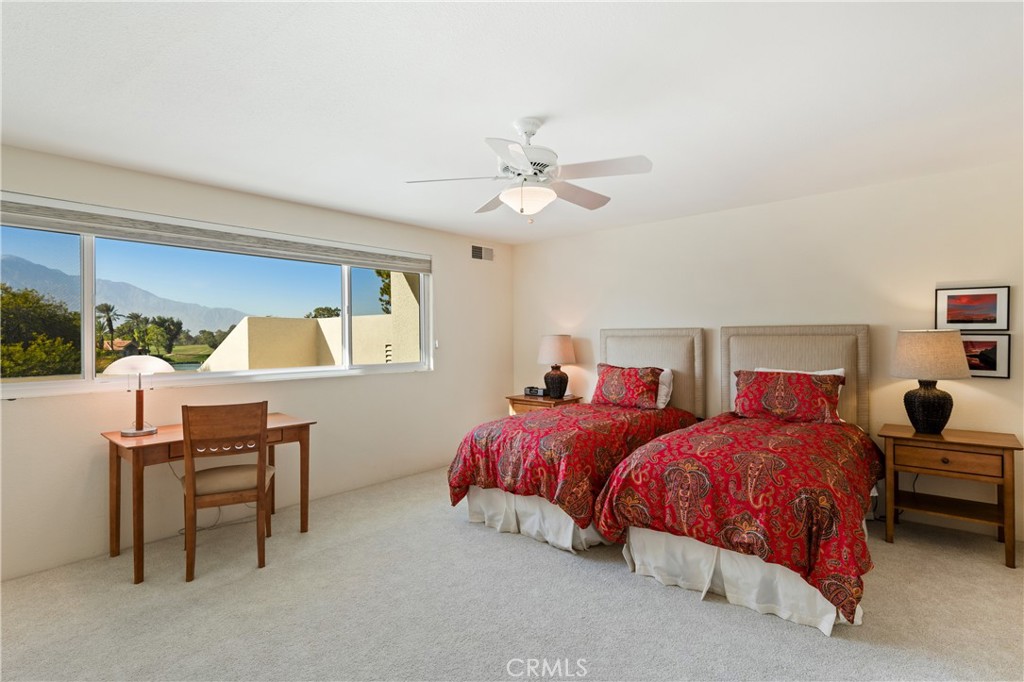 37 Oak Tree Drive Rancho Mirage, CA 92270 - Photo 27 of 54 a bedroom with two beds and a chandelier
