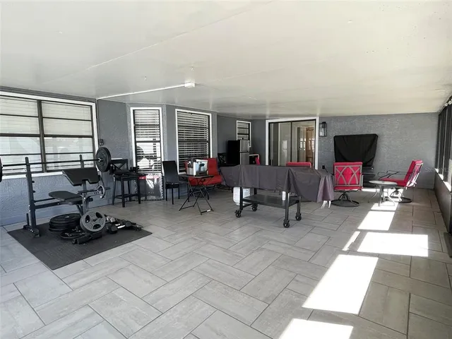 a living room with furniture a flat screen tv and a large window