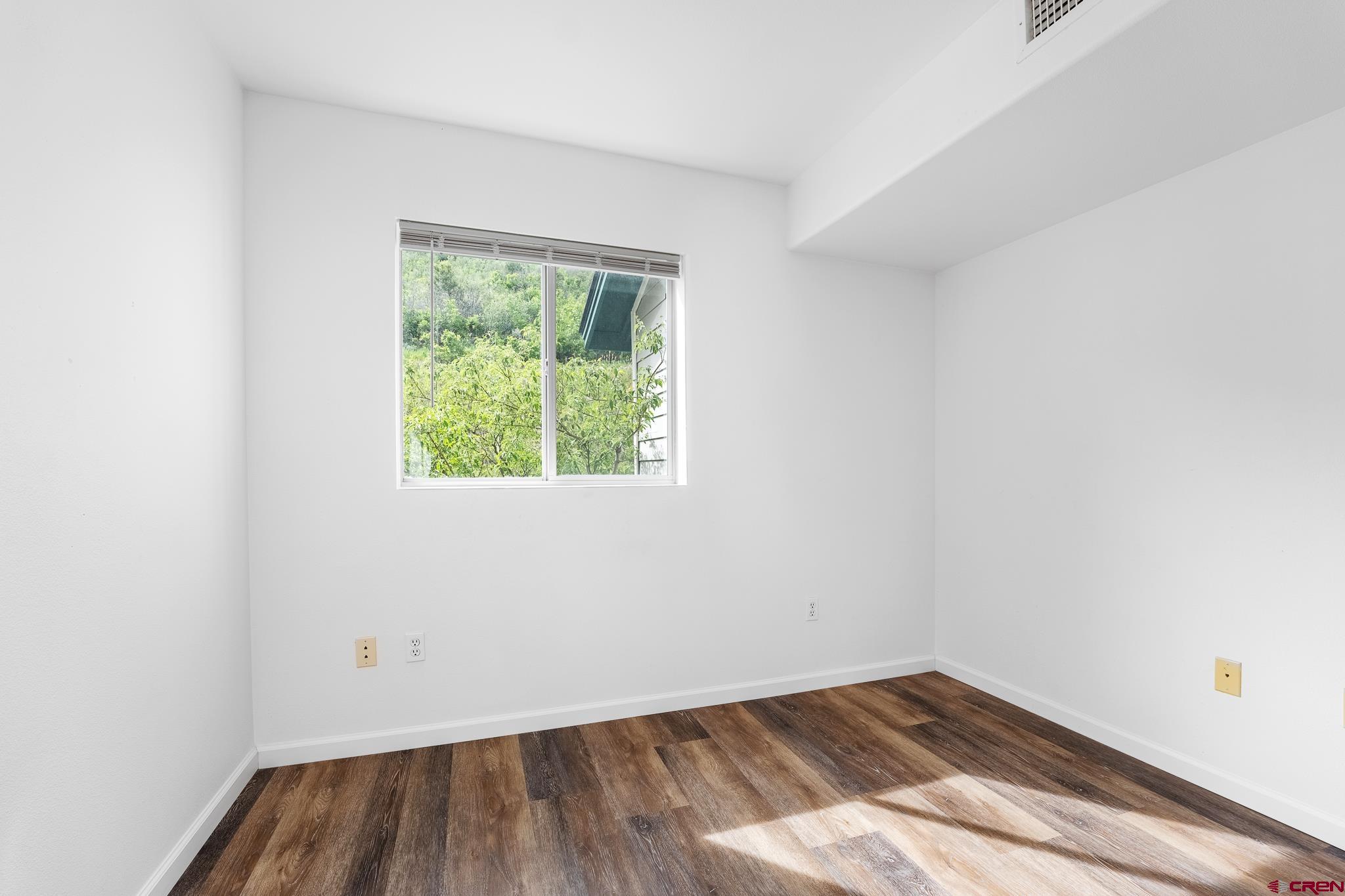 1100 Goeglein Gulch Road, Unit 164 Durango, CO 81301 - Photo 11 of 31 an empty room with wooden floor and windows