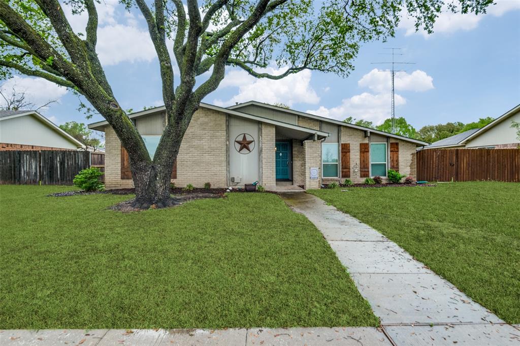 Mid-century home featuring a front yard, brick siding, and fence