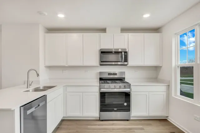 a kitchen with white cabinets stainless steel appliances and sink