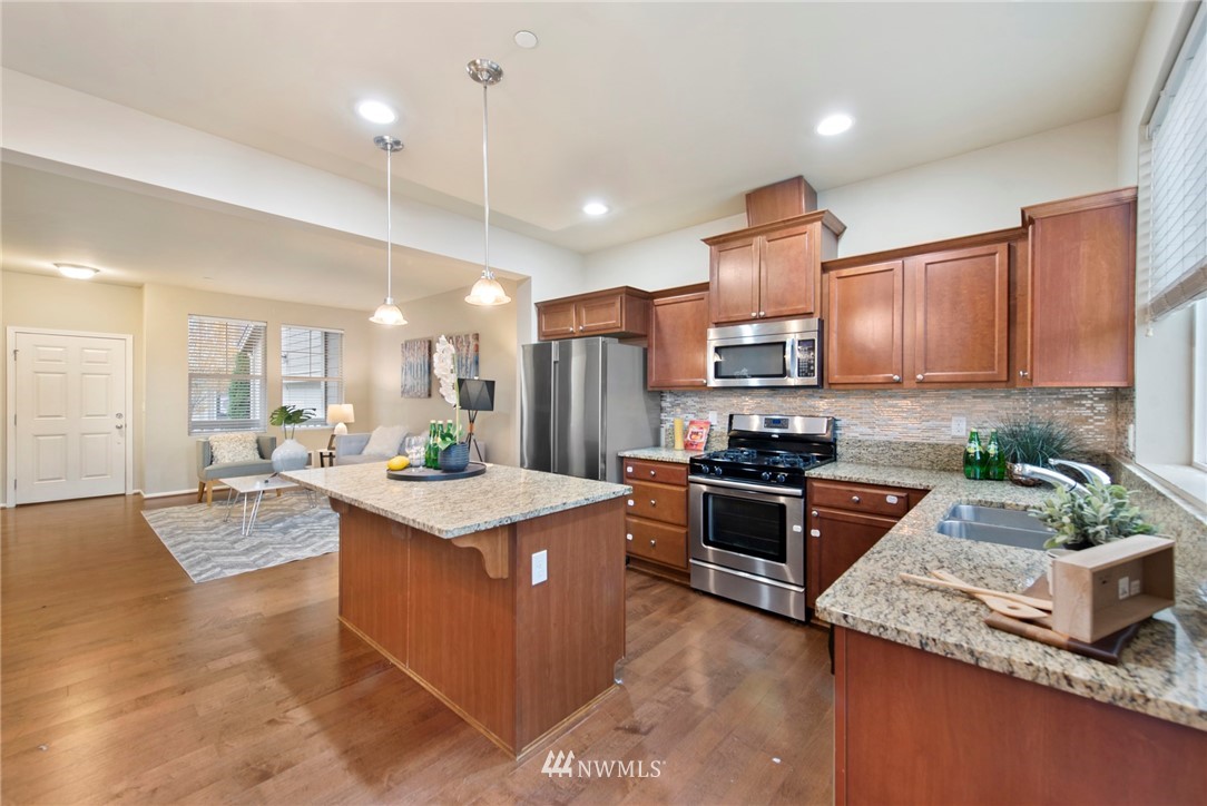 10719 Ross Road, Unit B Bothell, WA 98011 - Photo 4 of 26 a kitchen with granite countertop stainless steel appliances and wooden cabinets
