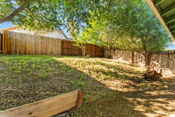 a view of a backyard with wooden fence