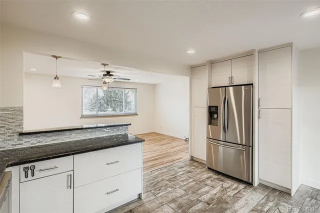 a kitchen with granite countertop a refrigerator and a sink