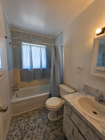 a bathroom with a granite countertop toilet a sink and a bathtub
