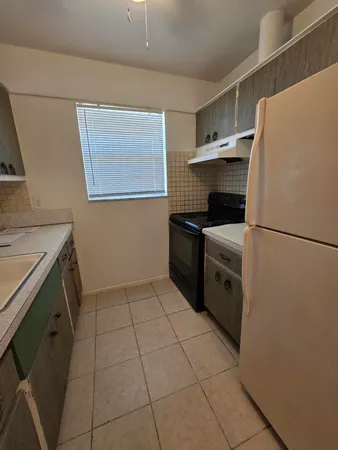 a kitchen with a sink a stove top oven and cabinets