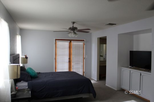 401 Ashton Street Ridgecrest, CA 93555 - Photo 24 of 36 a bedroom with a bed and a flat screen tv