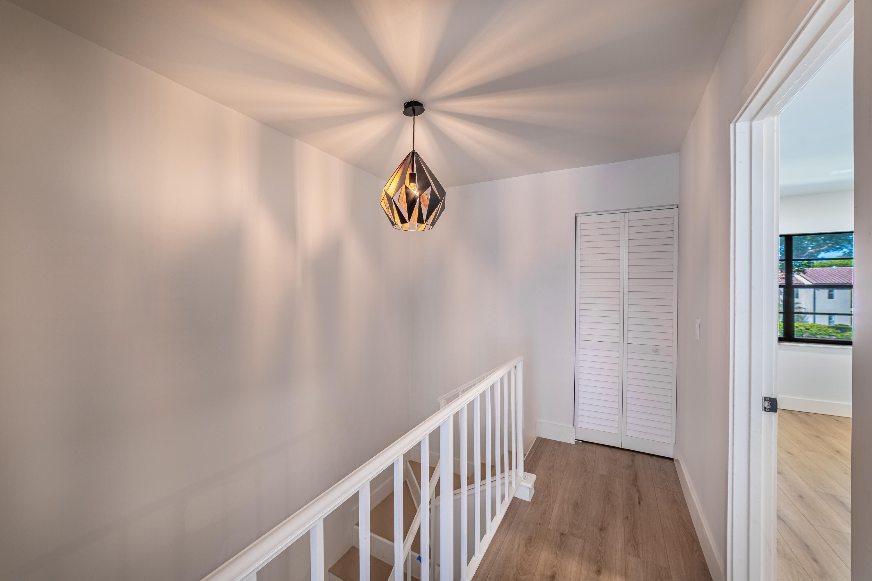 21864 Arriba Real, Unit 3E Boca Raton, FL 33433 - Photo 12 of 32 a view of a hallway with a window and a chandelier