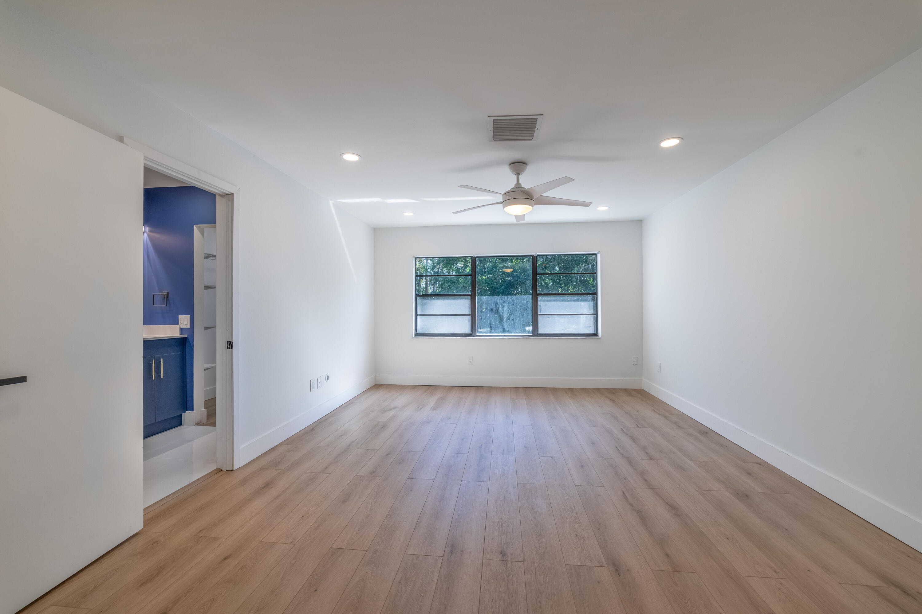 21864 Arriba Real, Unit 3E Boca Raton, FL 33433 - Photo 14 of 32 an empty room with wooden floor chandelier and windows