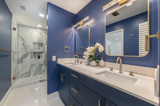 a bathroom with a double vanity sink mirror and shower