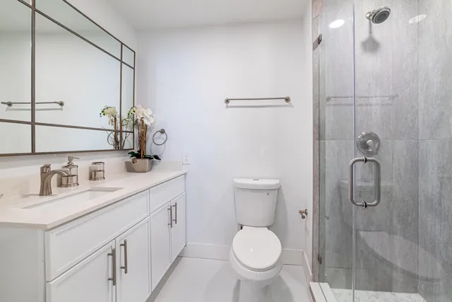 a bathroom with a granite countertop sink toilet and shower