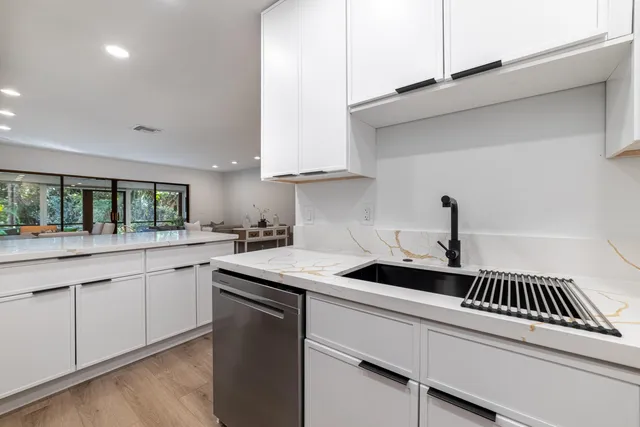 a kitchen with granite countertop a sink and cabinets