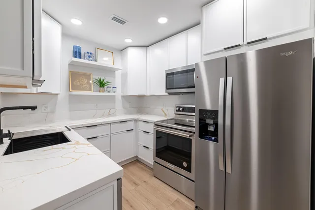 a kitchen with a sink stainless steel appliances and cabinets
