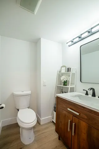 a bathroom with a toilet a sink and mirror