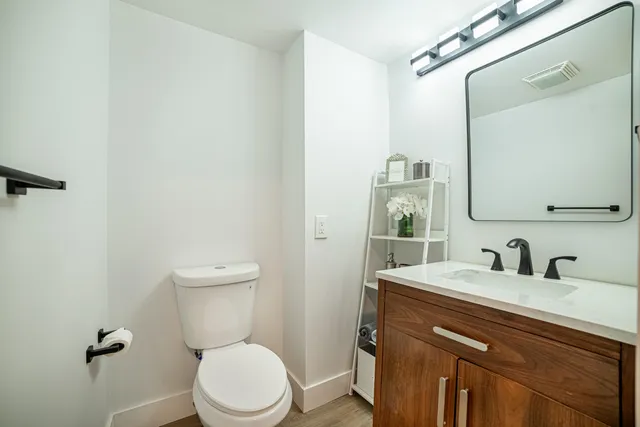 a bathroom with a toilet a sink and mirror