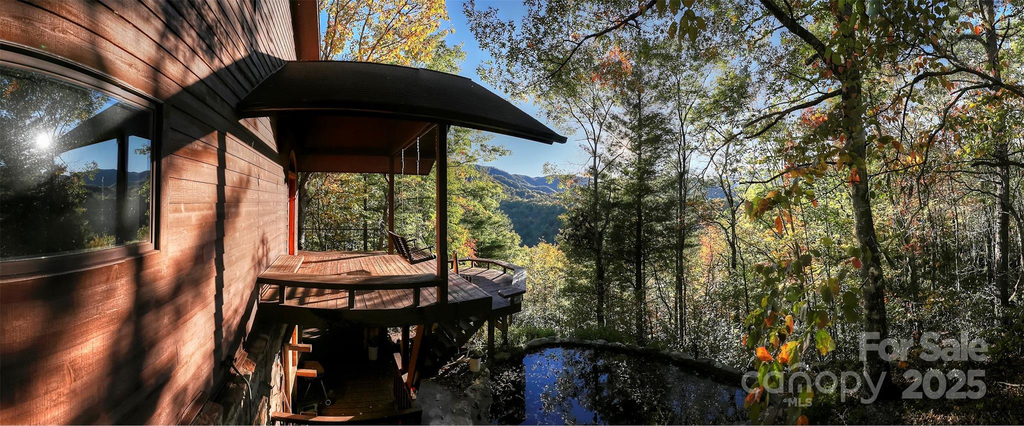 565 Silver Ridge Road Bryson City, NC 28713 - Photo 8 of 45 a backyard of a house with table and chairs under an umbrella