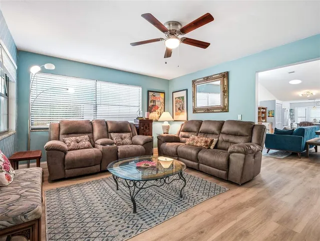 a kitchen with stainless steel appliances granite countertop a stove top oven a sink dishwasher and white cabinets with wooden floor