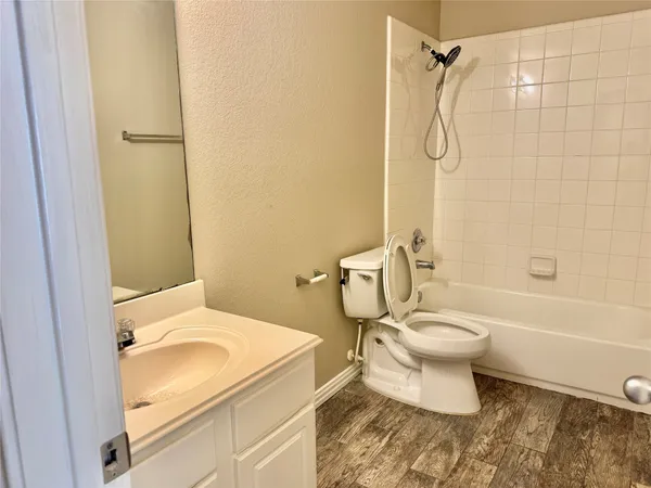 a white toilet sitting next to a bath tub and a shower