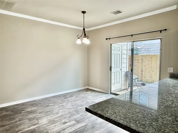 a view of a livingroom with a chandelier fan and wooden floor