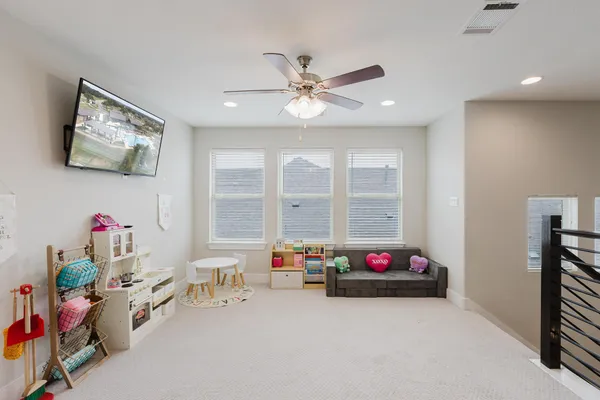 a living room with furniture a flat screen tv and a chandelier