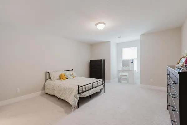 a bedroom with a bed and dresser