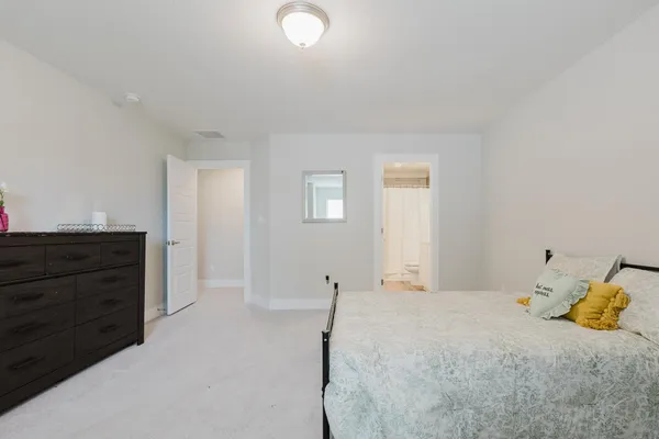 a bedroom with a bed and a dresser