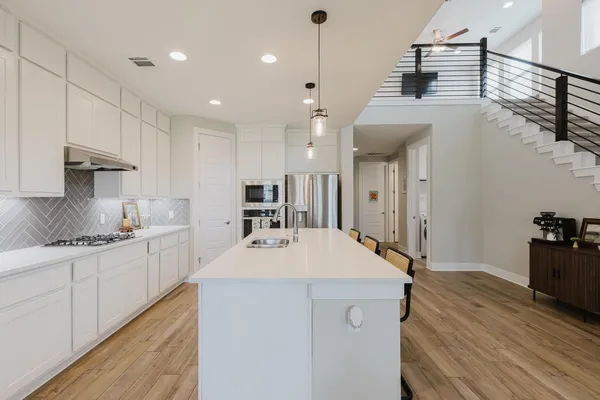 a large kitchen with kitchen island a sink stainless steel appliances and cabinets